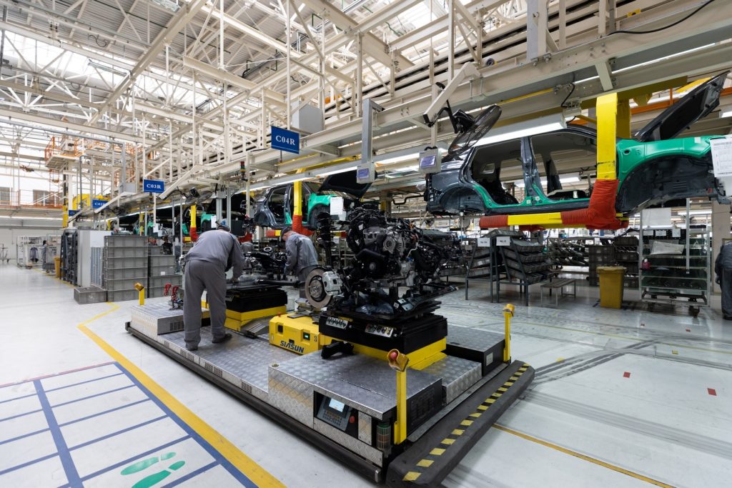 Photo of car bodies are on assembly line. Factory for production of cars. Modern automotive industry.